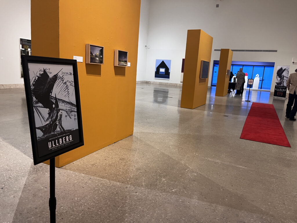 Art gallery display with posters and paintings.