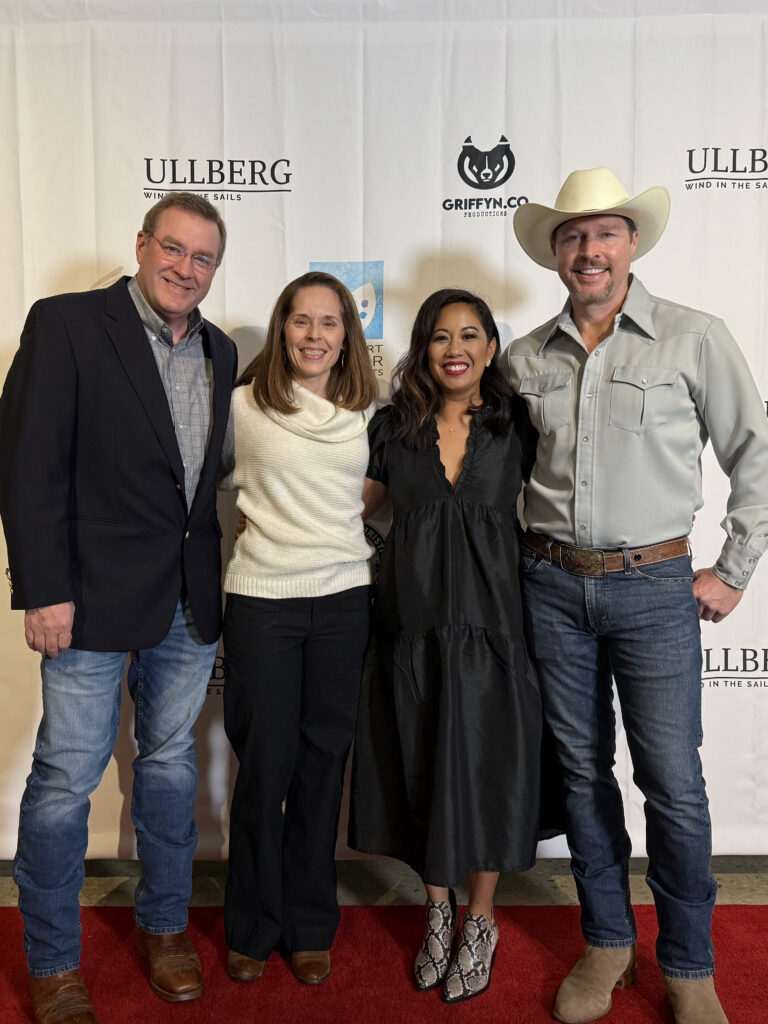 Four people posing on a red carpet