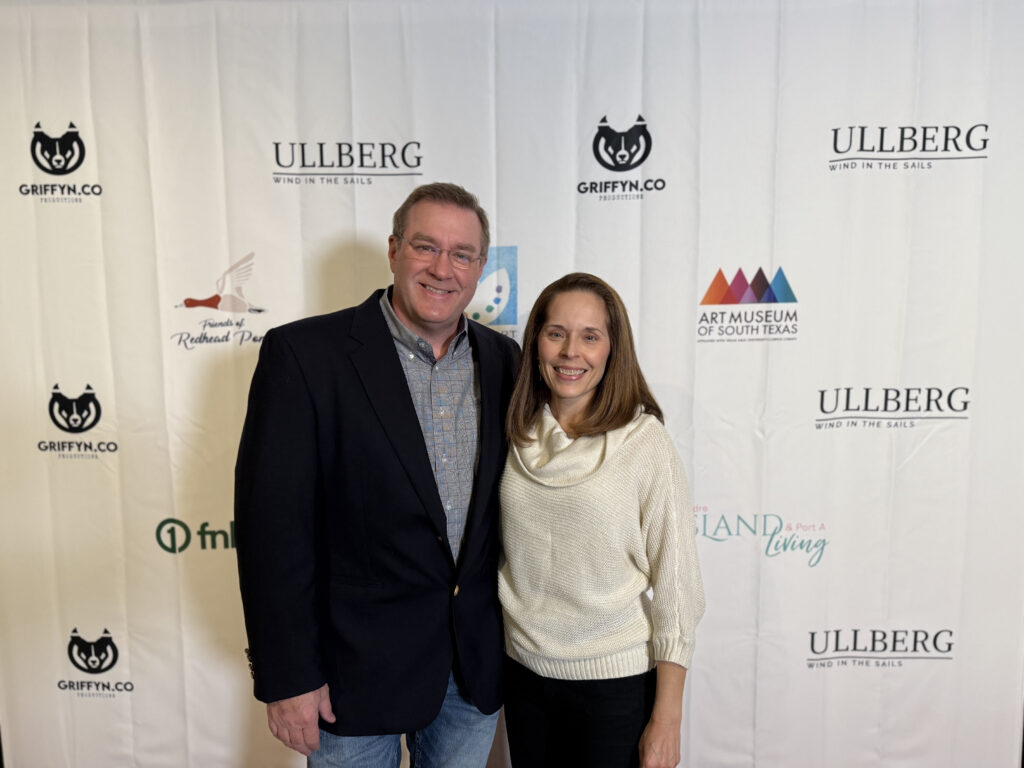 Couple smiling at art museum event backdrop.