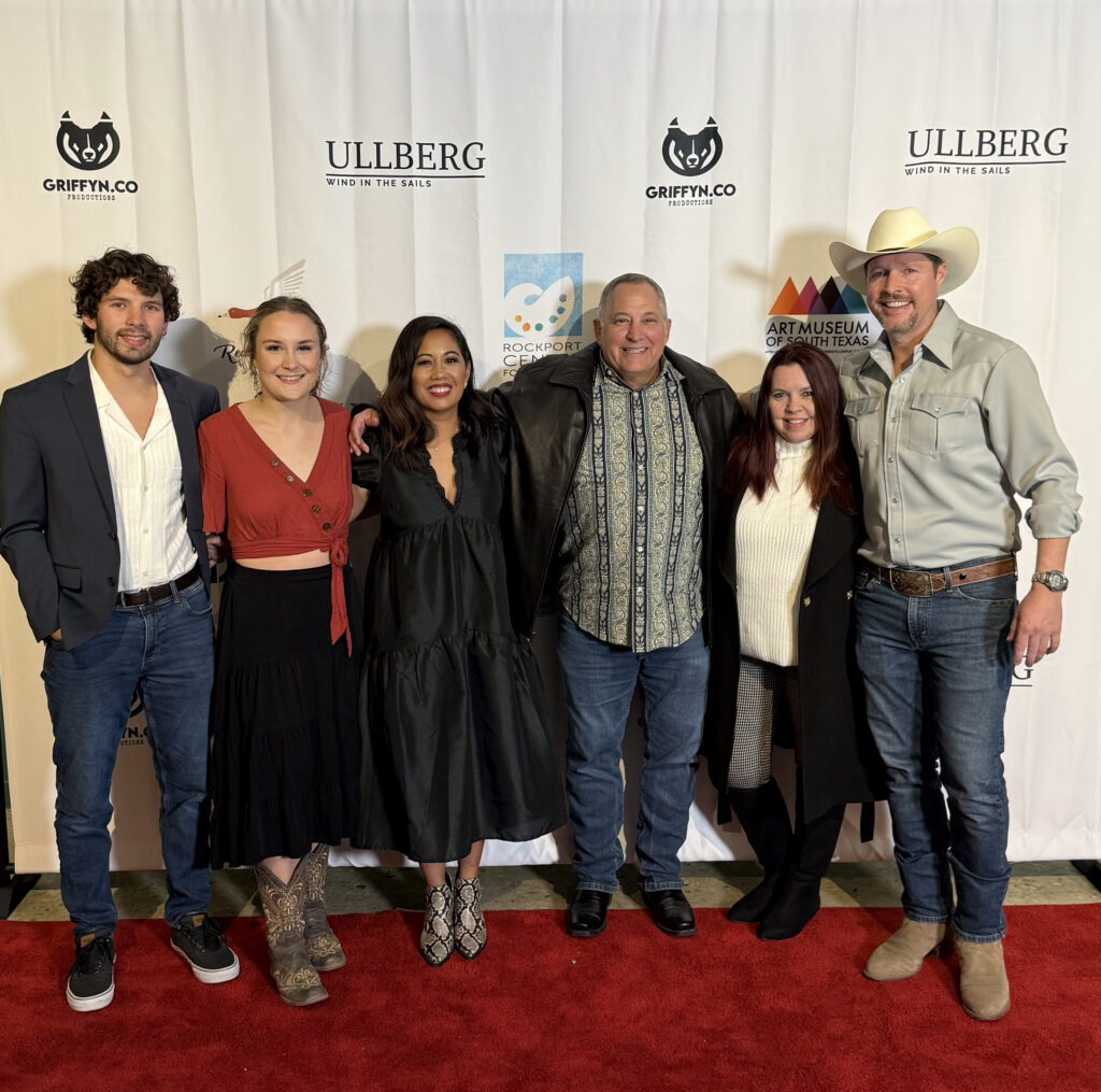 Group of six people on red carpet event.