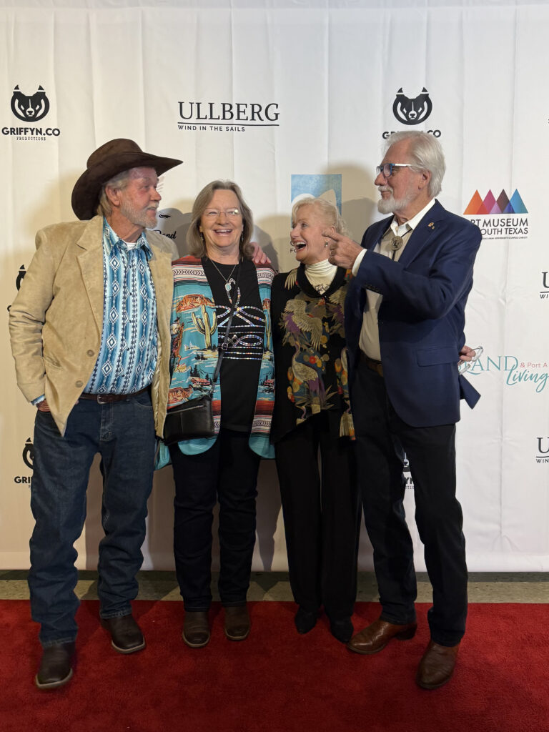 Four people smiling on red carpet event