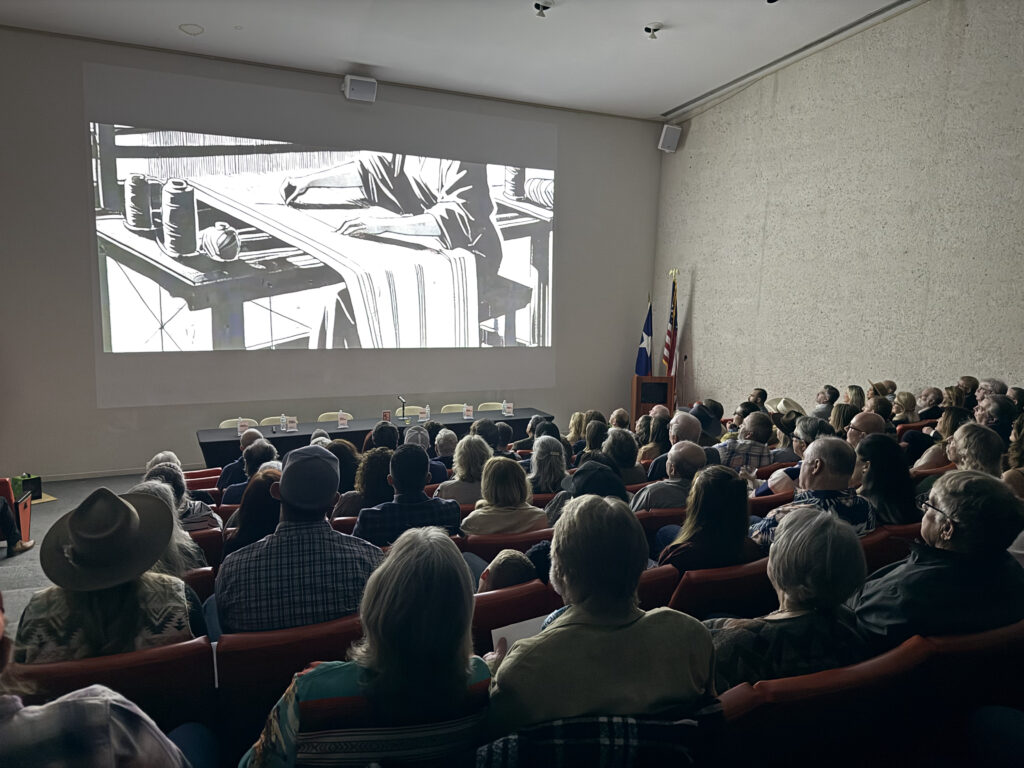 Audience watching black-and-white film in theater